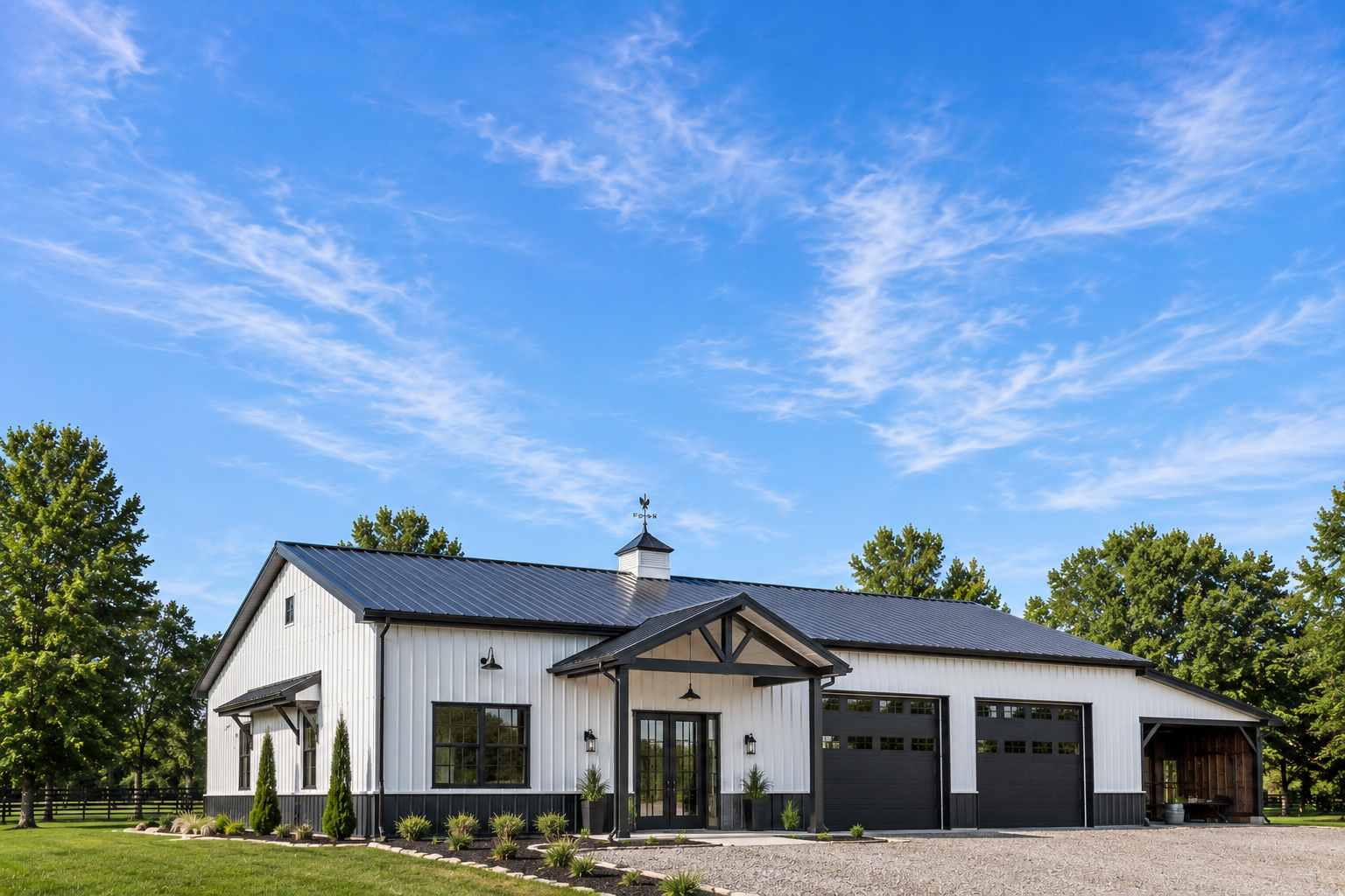 Custom metal building with living quarters and garage bays under a clear blue sky